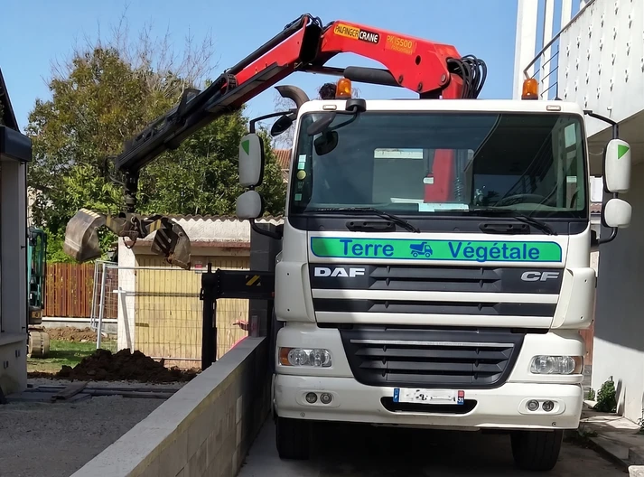 Camion benne avec grue pour livraison de terre végétale à Toulouse
