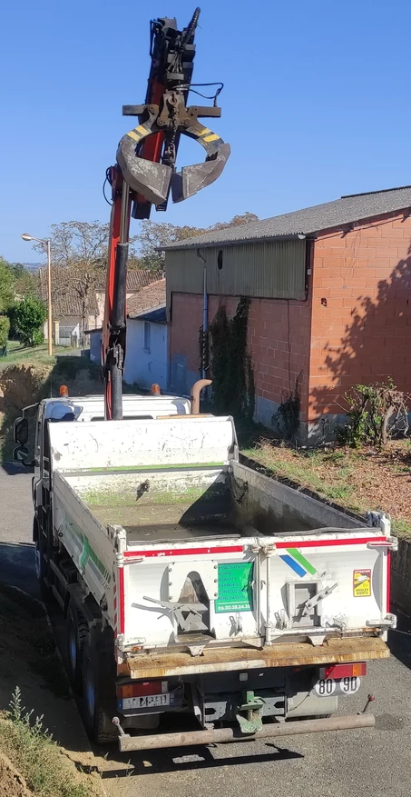 Camion avec grue pour livraison de terre végétale à Roques